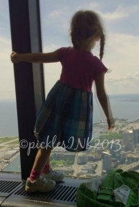 Child standing on the windowsill in the upper observation deck of the CN Tower.