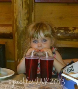 Child drinking from two glasses at the same time.