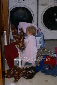 Baby Molly unloading clean laundry from basket.